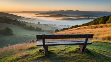 Obraz premium A wooden bench overlooking a serene, foggy mountain landscape at sunrise, perfect for tranquil moments, contemplation, and nature appreciation.