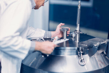 medicine science factory staff worker check quality products sterilize in autoclave tank in check...