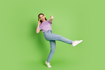 Full size photo of pretty young girl dance headphones point you wear trendy striped violet outfit isolated on green color background