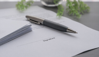 Papers, document and pen on the desk. Signature field of a highlighted document.