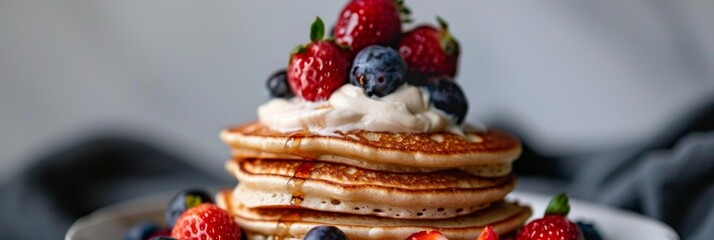A stack of fluffy avocado oil pancakes topped with fresh berries and a dollop of cashew cream a healthier and more refined alternative to traditional pancakes.