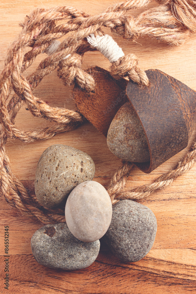 Wall mural antique sling shot and stones on a wooden table from the story of david and goliath in the bible