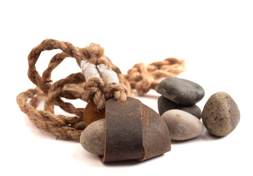Antique Sling Shot and Stones on a White Background from the Story of David and Goliath in the Bible