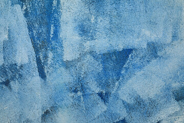 manchas brochazos de pintura blanca y azul sobre una pared gris con textura rugosa 4M0A0416-as24