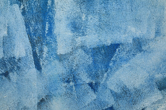 manchas brochazos de pintura blanca y azul sobre una pared gris con textura rugosa 4M0A0416-as24