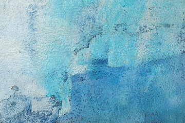 manchas brochazos de pintura blanca y azul sobre una pared gris con textura rugosa 4M0A0419-as24