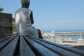 mujer mayor sola pensativa sentada mirando el mar getaria país vasco 4M0A1014-as24