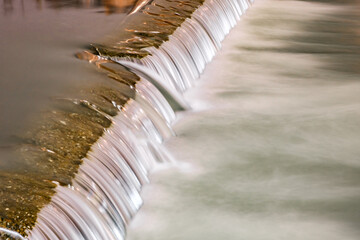 water flows from threshold on river, blurred movement of water