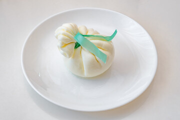 Burrata cheese on plate, selective focus