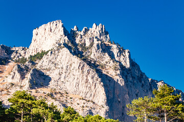 sheer cliff with peaks in mountainous area