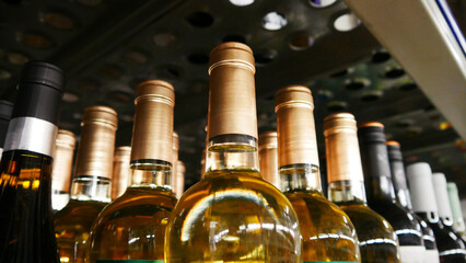 Many golden bottles of wine on a retail display