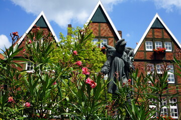 Fachwerkhäuser mit Backstein und Spitzgiebel mit dem Kiepenkerl Denkmal vor blauem Himmel bei...