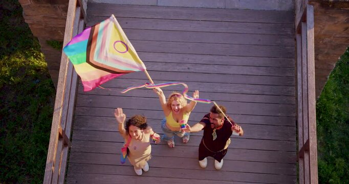 people in gay pride parade day whit LGBT new progess flag  from a high shot cenital top view camera 