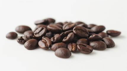 Small pile of whole coffee beans scattered on a smooth white surface