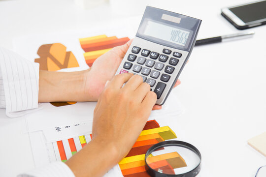 Business accounting concept, Business woman using calculator with computer laptop, budget and loan paper in office.
