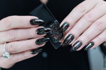 Female hands with long nails and black manicure 