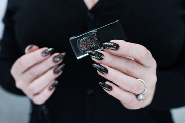 Female hands with long nails and black manicure 