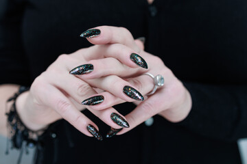 Female hands with long nails and black manicure 