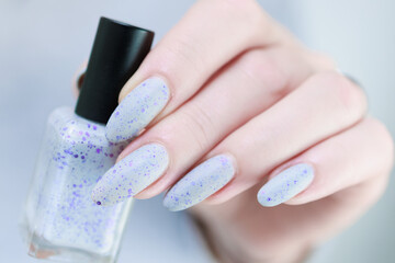 woman hands with long nails light gray blue manicure