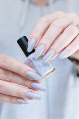 woman hands with long nails light gray blue manicure