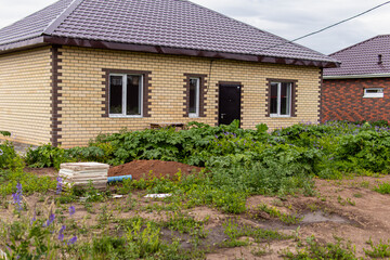 Unsold country house, area overgrown with hogweed. Abandoned new house