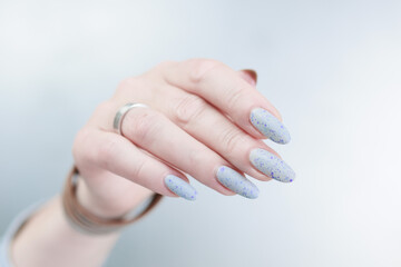 Female hand with long nails and a white gray and purple manicure