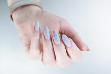 beautiful female hands with long nails light gray manicure