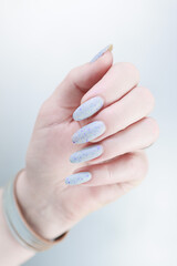 beautiful female hands with long nails light gray manicure