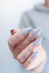 Female hand with long nails and a white gray and purple manicure