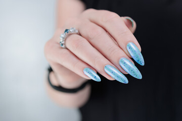 Female hand with long nails and light blue manicure