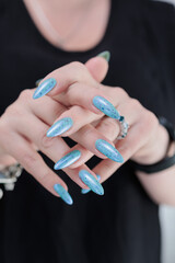 Female hand with long nails and light blue manicure