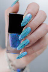 Female hand with long nails and light blue manicure