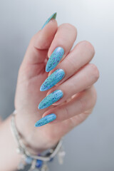 Female hand with long nails and light blue manicure
