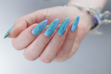 Female hand with long nails and light blue manicure