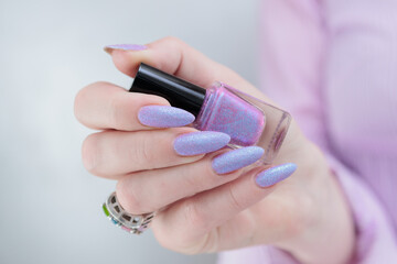 Woman hand with long nails manicure and light blue and pink nail polish
