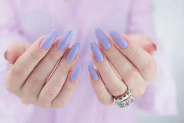 Woman hand with long nails manicure and light blue and pink nail polish