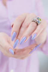 Woman hand with long nails manicure and light blue and pink nail polish