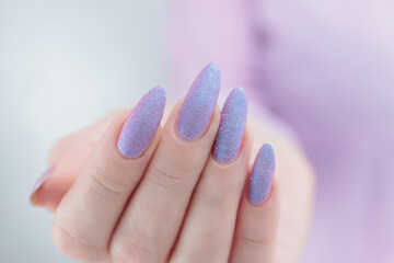 Woman hand with long nails manicure and light blue and pink nail polish