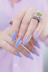 Woman hand with long nails manicure and light blue and pink nail polish