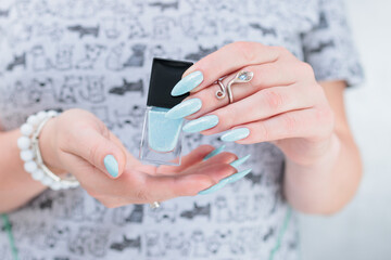 Woman's beautiful hand with long nails and light blue manicure