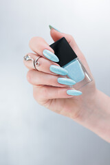 Fototapeta premium Female hand with long nails and light blue manicure