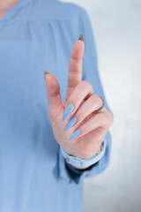 Naklejka premium Woman's beautiful hand with long nails and light baby blue manicure