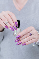 Female hand with long nails and purple plum manicure