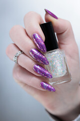 Female hand with long nails and purple plum manicure