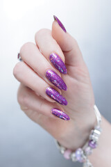 Female hand with long nails and purple plum manicure
