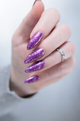 Female hand with long nails and purple plum manicure