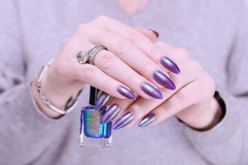 beautiful female hand with long nails, golden, purple and blue manicure	