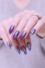 beautiful female hand with long nails, purple and blue manicure 