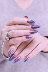 beautiful female hand with long nails, purple and blue manicure 