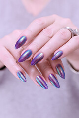 Fototapeta premium beautiful female hand with long nails, golden, purple and blue manicure 